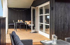 Een buitenzitplaats met een tafel, stoelen en een bank.