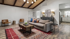A spacious living area with a high ceiling, a sofa set, a coffee table, and a patterned rug. - LAKEFRONT Bliss FLAT to water: Spacious home with Game Room, Sleeps 15 Guests!  (Garfield)