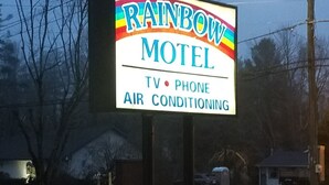 A motel sign with amenities including TV, phone, and air conditioning.