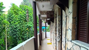 A covered corridor with tiled flooring, stone walls, and wooden railings. Yellow safety mats are placed along the path. - Carpe Diem (Cairu)