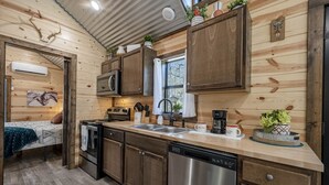 Una cocina compacta con armarios de madera, lavavajillas y cafetera.