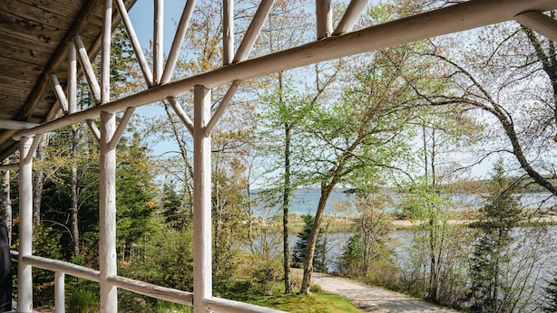 Eine Holzterrasse mit Blick auf einen See und Bäume.