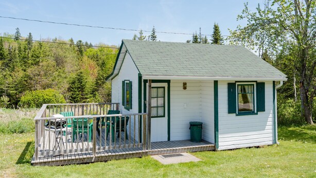 A small white cabin with green trim and a porch, surrounded by greenery. - Orchard Cabin #4 - Hubbards Beach (Hubbards)