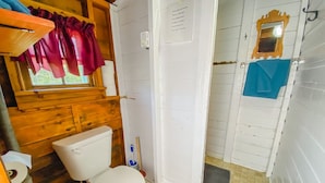 A small, compact bathroom with a toilet, a shower stall, and a sink. - Orchard Cabin #4 - Hubbards Beach (Hubbards)