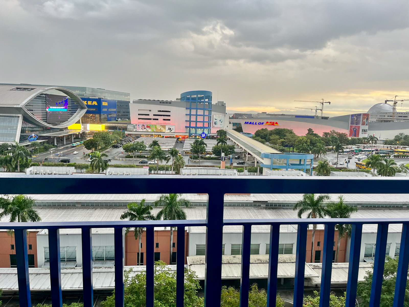 A cityscape with a prominent mall, a curved building, and a bridge.