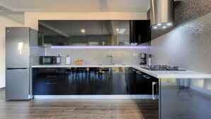 Eine moderne Küche mit glatten Schränken, einem Edelstahlkühlschrank und einem eingebauten Backofen.