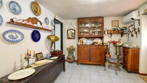 Eine traditionelle Küche mit einer Holztheke, einem Grammophon und verschiedenen dekorativen Tellern an der Wand.