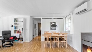 Ein modernes Wohnzimmer mit Essbereich, Kamin und Bücherregal.