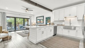 A modern kitchen with white cabinetry, a built-in dishwasher, and a large island. - Palms of Seagrove D5 -Private Beach Access, Bikes, Pool & 5 Min to Seaside (Seagrove Beach)