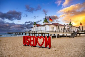 Un edificio frente al mar con un muelle, banderas y un cartel que dice 'USEDOM'.