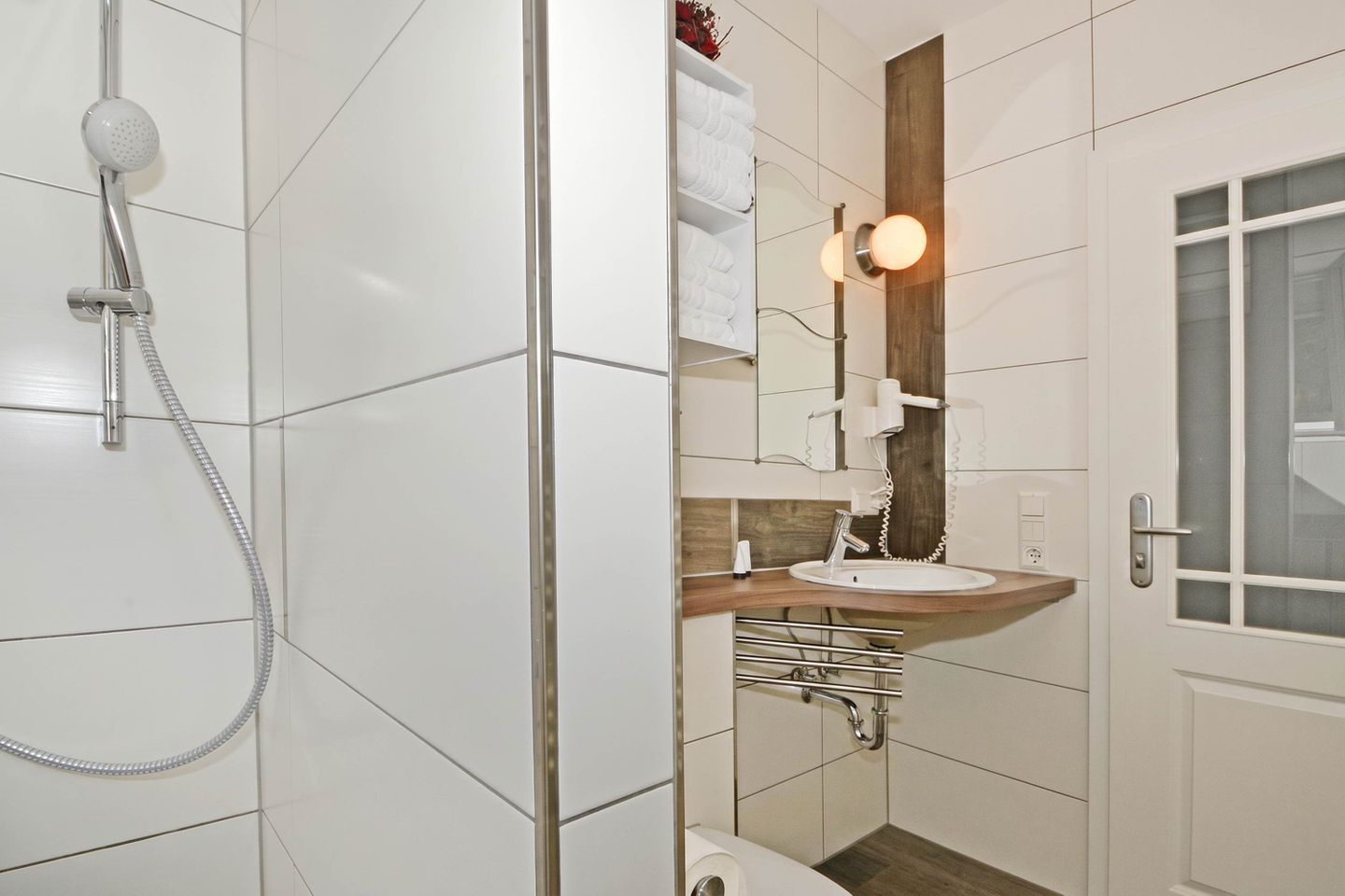 Ein modernes Badezimmer mit Dusche, Waschbecken und Spiegel.