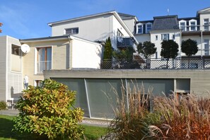 Ein modernes Wohngebäude mit flachem Dach, Satellitenschüssel und Garagentor.
