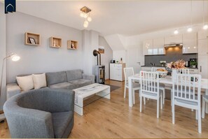 A modern apartment with a living room, dining area, and kitchen. - DHH Anemone - Gemütliche Doppelhaushälfte für bis zu 6 Personen, mit Kamin und Terrasse (Korswandt)