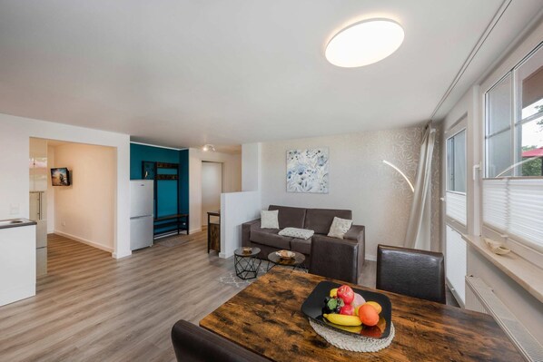 A modern apartment with a dining area, a living room, and a kitchen.