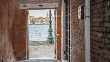 Un stretto vicolo con vista su un canale e palazzi sullo sfondo.