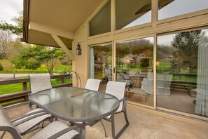 Relax in this serene outdoor space, featuring a glass-top table and comfortable seating for four.