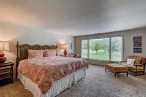 Relax in a spacious room with a large bed, comfortable seating, and a reading nook.