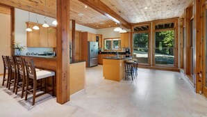 Une cuisine spacieuse avec des meubles en bois, un îlot central et des tabourets de bar.