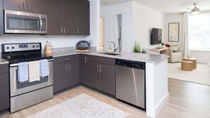 Una cocina moderna con armarios oscuros, electrodomésticos de acero inoxidable y una isla central.