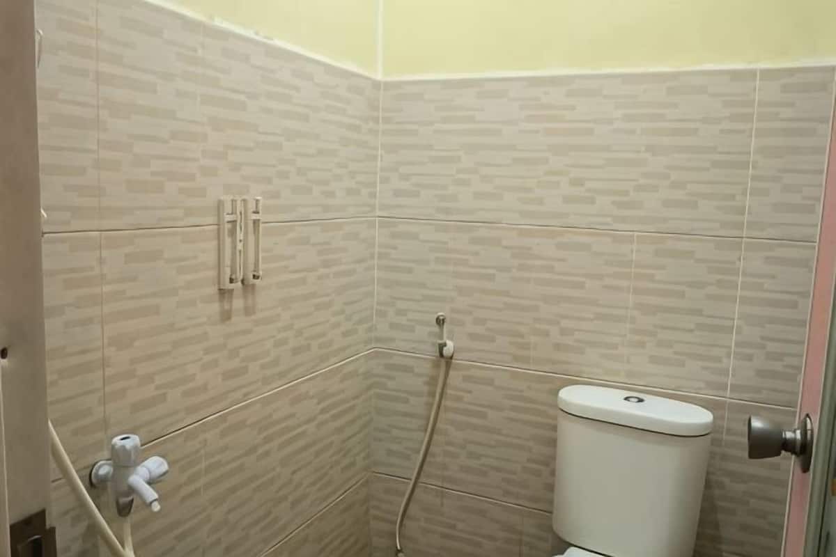 Een badkamer met toilet, douche en handdoekhouder.
