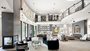 A spacious living area with a fireplace, modern furniture, and artwork on the walls.