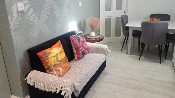 A modern living room with a sofa, a dining table, and chairs. - Apartment - Sleeps 4 - Parking - WiFi (Greater London, Dagenham)
