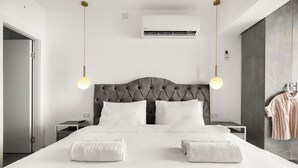 A hotel room with a large bed, two bedside tables, an air conditioning unit, and a wall-mounted light fixture. - Sea of Galilee Panorama Apt by SeaN'Rent (Tiberias)