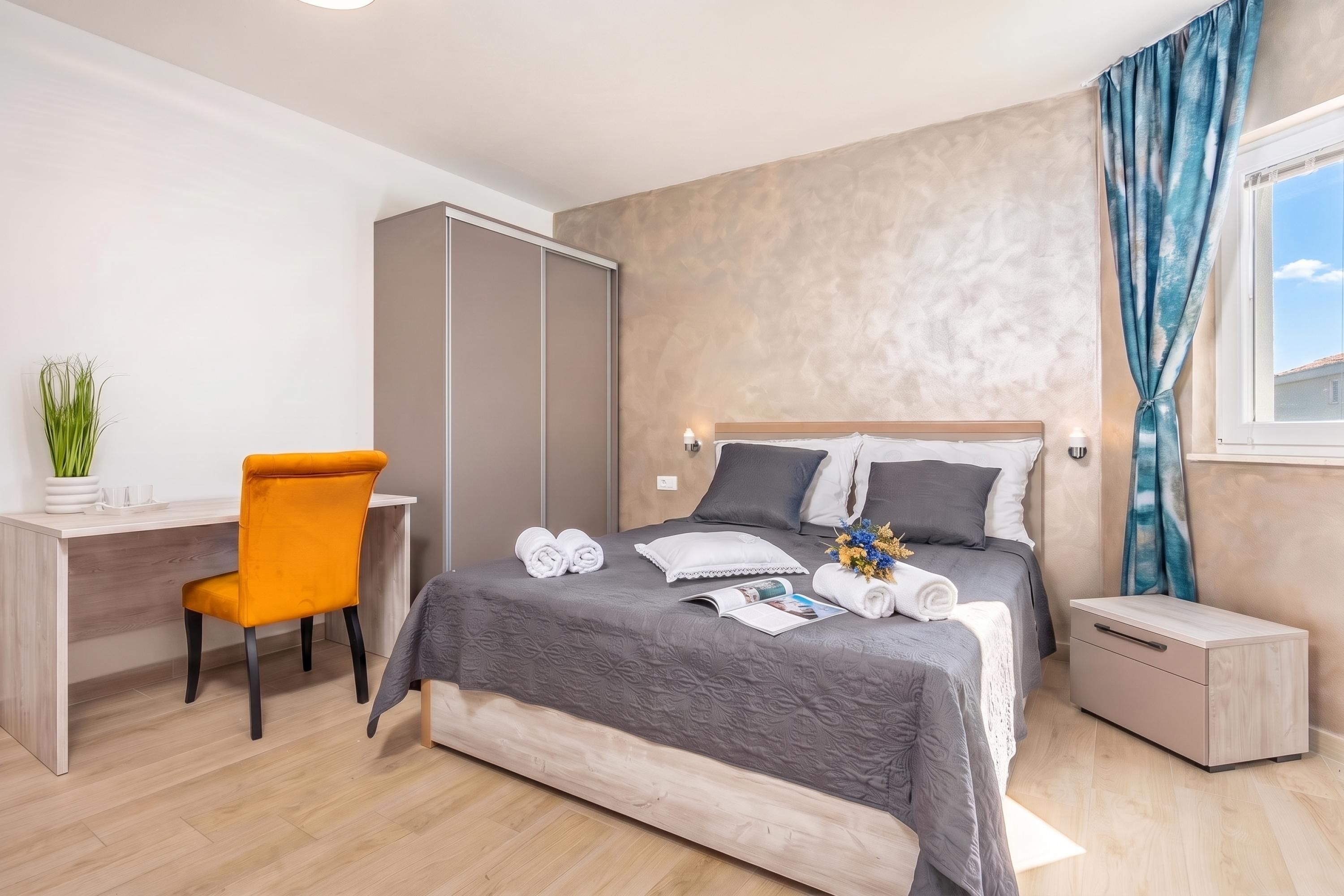 Een moderne slaapkamer met een bed, een bureau en een stoel.