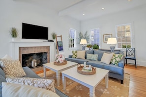 Una sala de estar con chimenea, televisor y sofá.