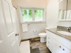 Une salle de bain avec des toilettes, un lavabo et une fenêtre.