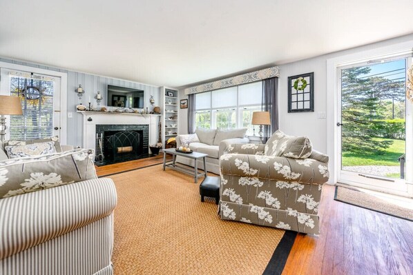 A living room with a fireplace, a sofa, a chair, and a coffee table.