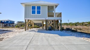 A beachfront house with a balcony, elevated on stilts, and a clear view of the beach. - Modern Little Beach House- Steps to the Beach (Gulf Shores)