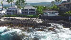 Un hotel costero con varias edificaciones, un litoral rocoso y vistas al océano.