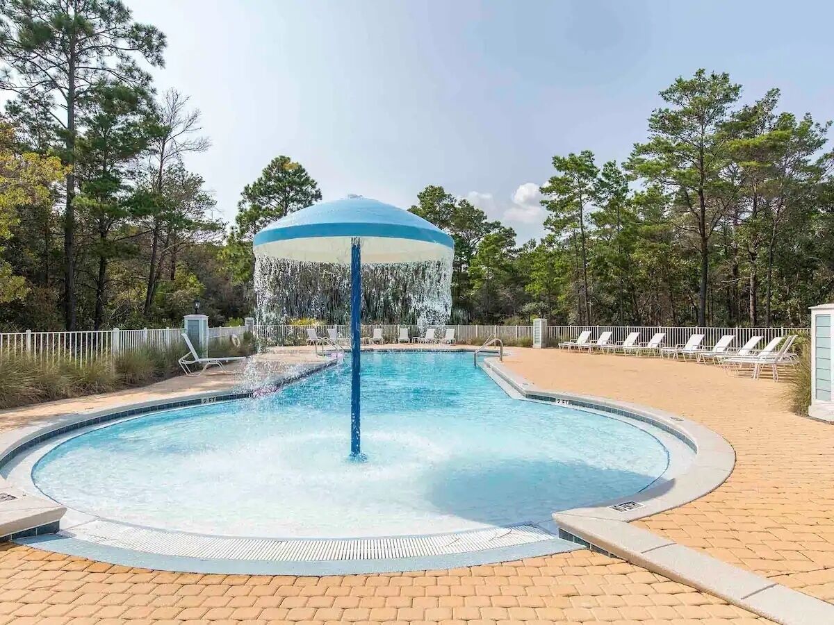 A circular pool with a central water feature and a gazebo-like structure.