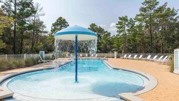 A circular pool with a central water feature and a gazebo-like structure.