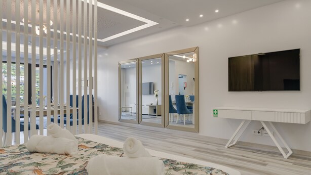 Une chambre d’hôtel moderne équipée d’un lit, d’une télévision et d’un bureau.