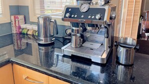 A coffee machine on a kitchen counter with a kettle and coffee cups. - The peaceful retreat in a tranquil court (Mulgrave)