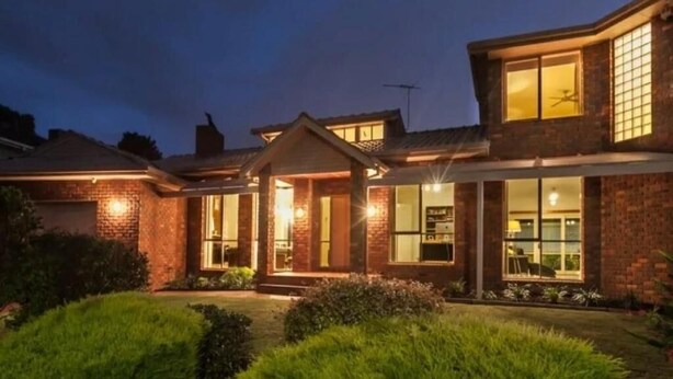 A two-story house with a brick exterior, large windows, and a well-lit front porch. - The peaceful retreat in a tranquil court (Mulgrave)