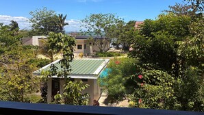 A residential area with houses, lush greenery, and a clear blue sky. - The Lazy Tiki (Buenavista)