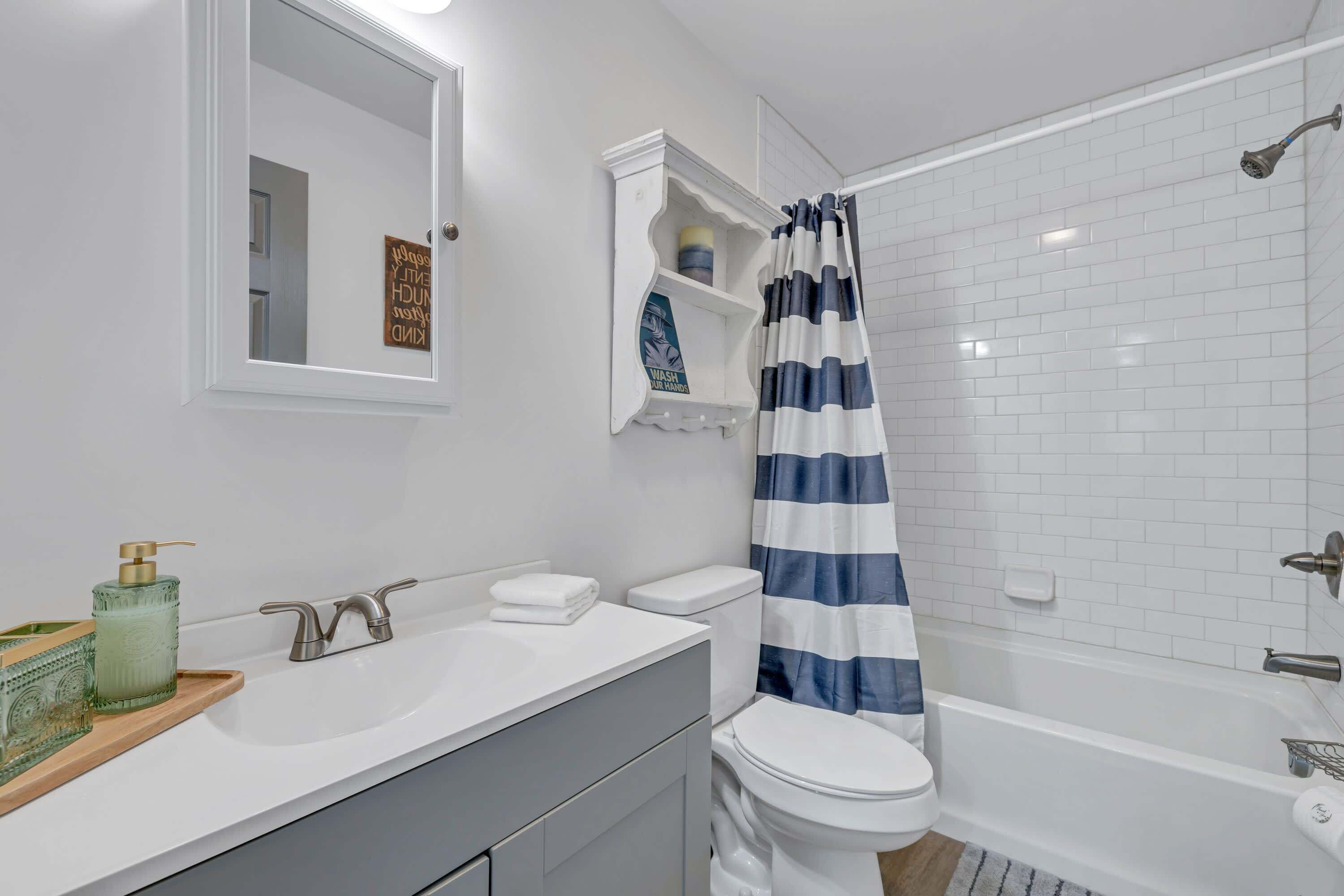 Une salle de bain avec un lavabo blanc, des toilettes et une baignoire.