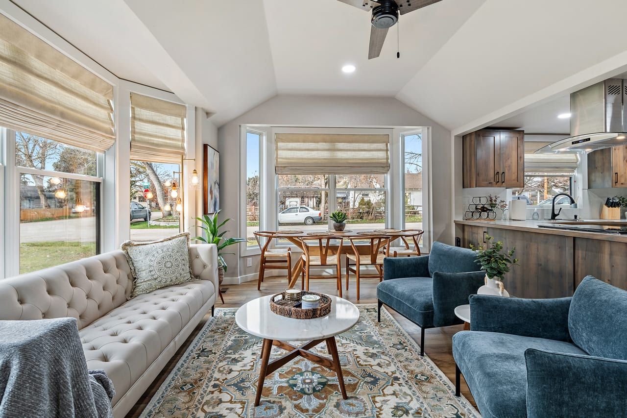 A spacious living area with a sofa, chairs, and a dining table.