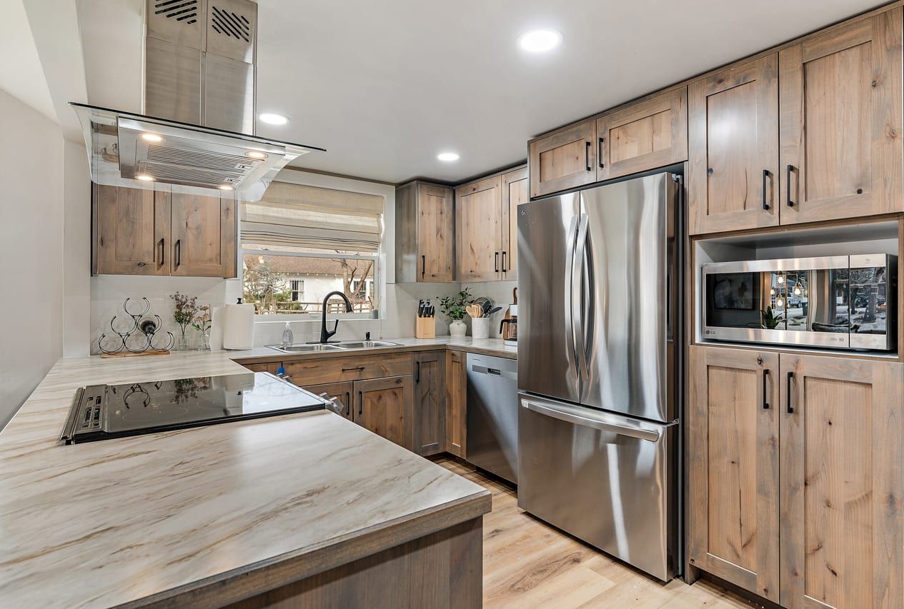 Una cocina moderna con armarios de madera, electrodomésticos de acero inoxidable y una isla grande.