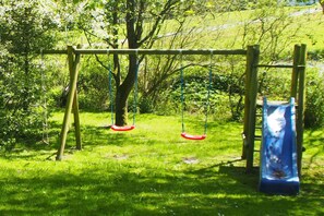 A playground with swings and a slide. - Holiday home Ockholm (Ockholm)