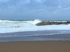 Une plage où les vagues s’écrasent contre les rochers.