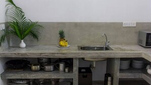 A kitchen with a granite countertop, a sink, and various kitchen utensils and appliances.
