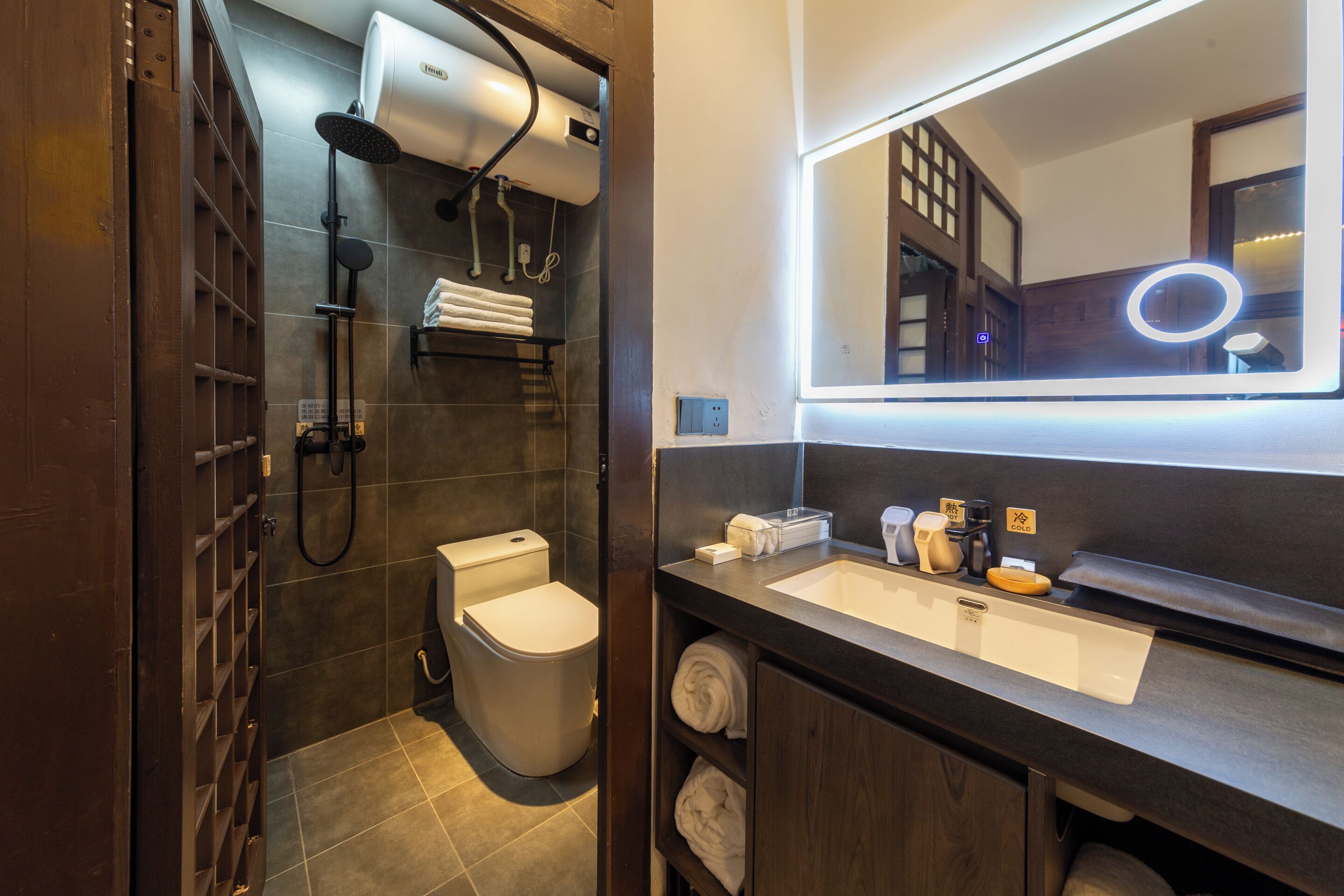 A modern bathroom with a built-in shower, a toilet, and a vanity with a mirror.