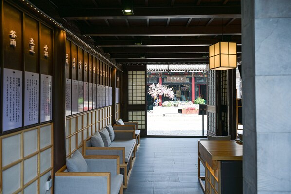 A traditional Japanese interior with tatami mats, low wooden tables, and a view of cherry blossoms outside.