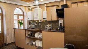 A modern kitchen with built-in appliances, a sink, and a dining area with a table and chairs. - Har-Mar Hotel (Goris)