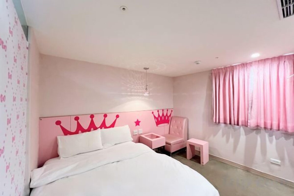 Une chambre à coucher avec un lit, une table de chevet, une chaise et une fenêtre avec des rideaux.