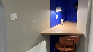 A corner room with a wooden desk, a chair, a lamp, and a telescope. - La Madeleine Jolie Studio en Hyper Centre (Rennes)